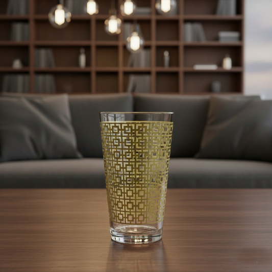 Luxe Gold pint beer glass with a gold lattice design on a wooden table in a living room setting.