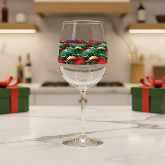 Royal Flux tall wine glass with red, green and gold wave design on a kitchen counter with gift boxes.