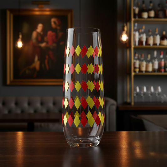 Ruby and gold harlequin design stemless champagne flute glass with harlequin design on a bar counter