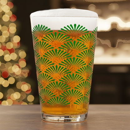 Green Deco pint glass with an Art-Deco green design, filleed with beer, and on a blurred festive background