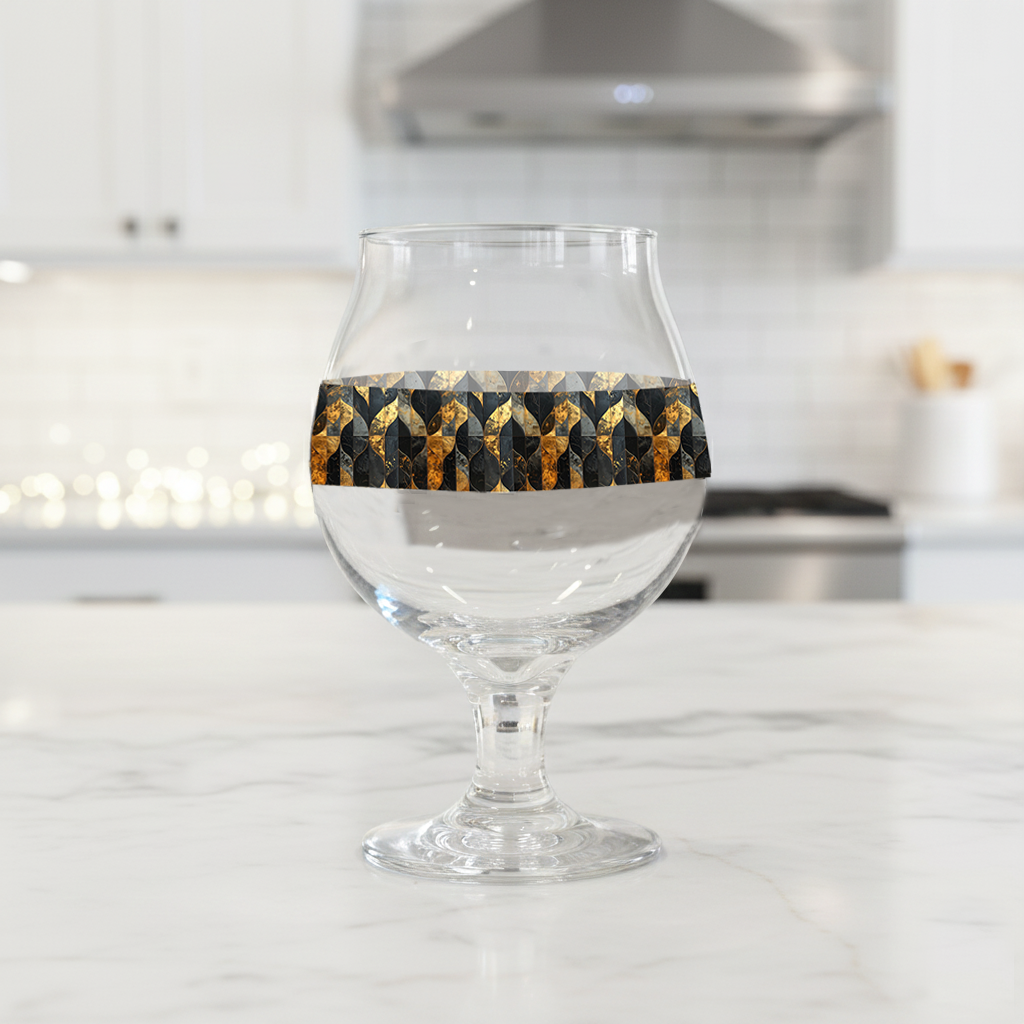 Aged Elegance Belgian beer glass with a black and bronze geometric design on a kitchen counter