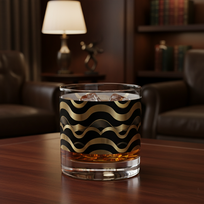 Liquid Gold whiskey glass with gold and black Art-Deco design on a wooden table in a cozy room.