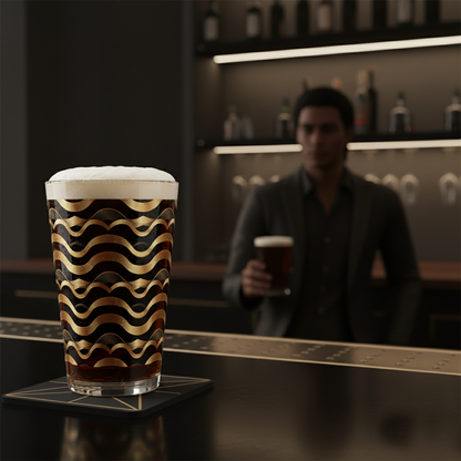 Liquid Gold pint glass of beer with black and gold Art-Deco design on a bar counter,and blurred bar scene in the background