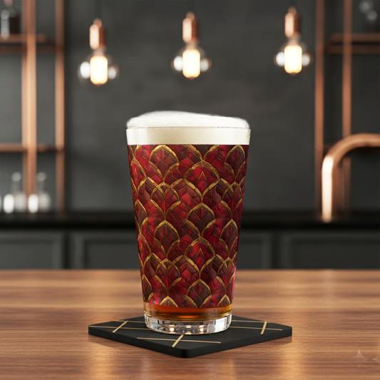 Crimson Jewels pint glass with ruby and gold design, filled with beer and foam head on a coaster in a bar setting