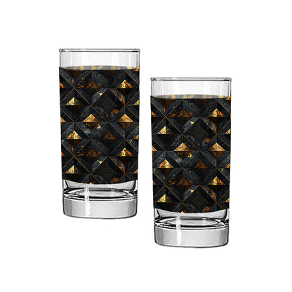 Two highball glasses with geometric black and gold pattern on a white background