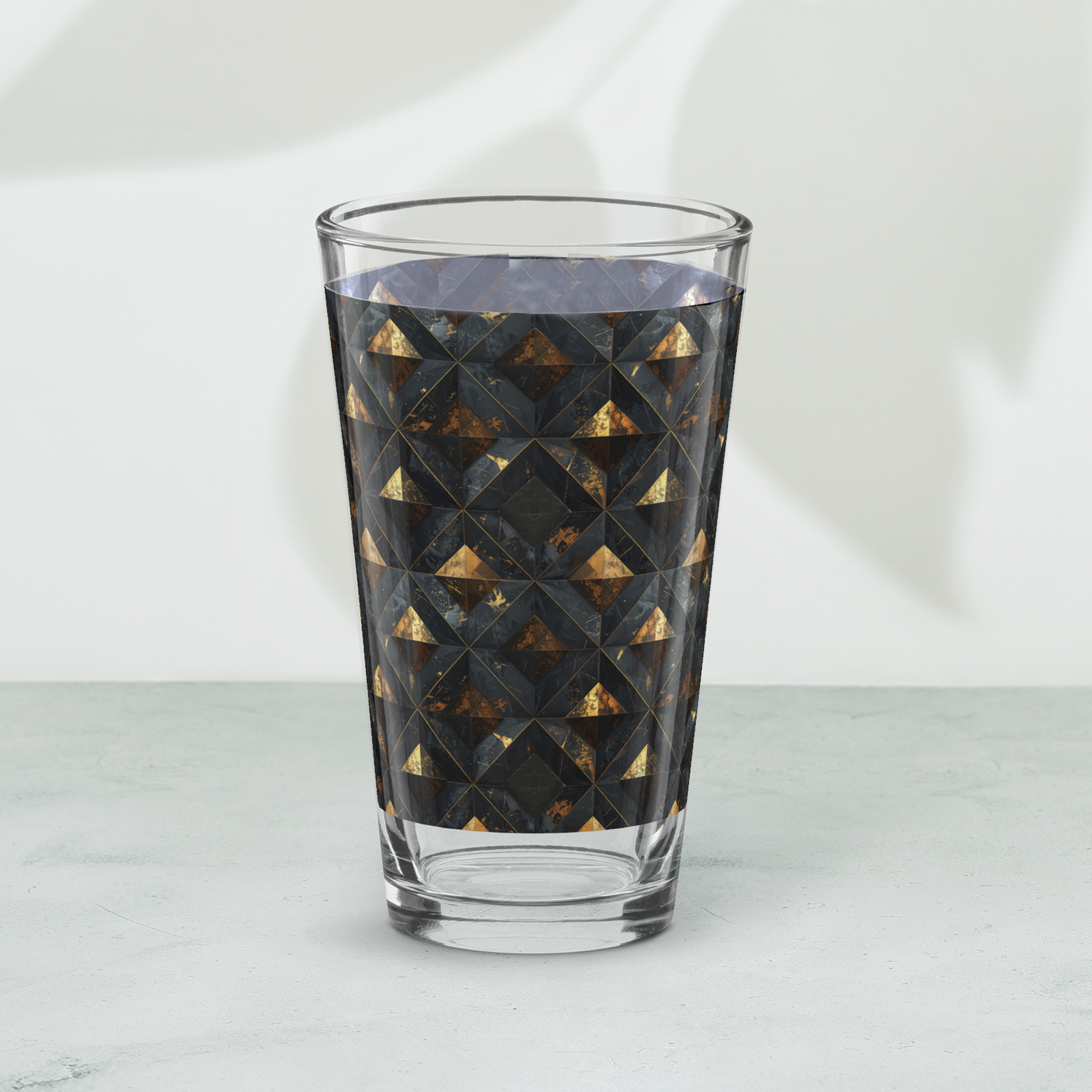Gilded Decay pint beer glass with charcoal and gold geometric pattern on a white background