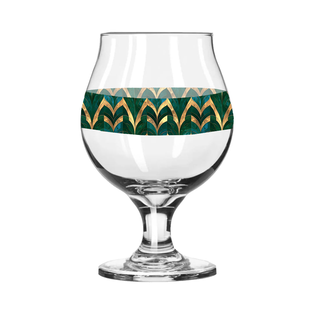Belgian beer glass with green and gold geometric design on a white background