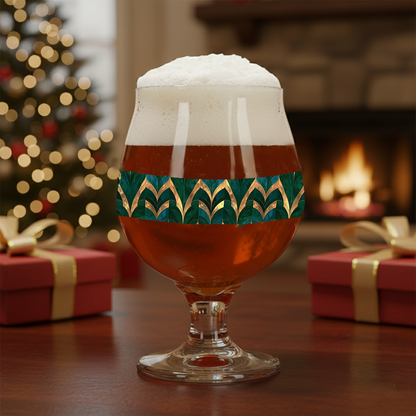 Emerald Royale Belgian glass of beer with decorative green and gold pattern in a setting with presents and blurred Christmas tree and fireplace in background