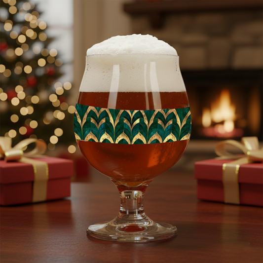 Emerald Royale Belgian glass of beer with decorative green and gold pattern in a setting with presents and blurred Christmas tree and fireplace in background