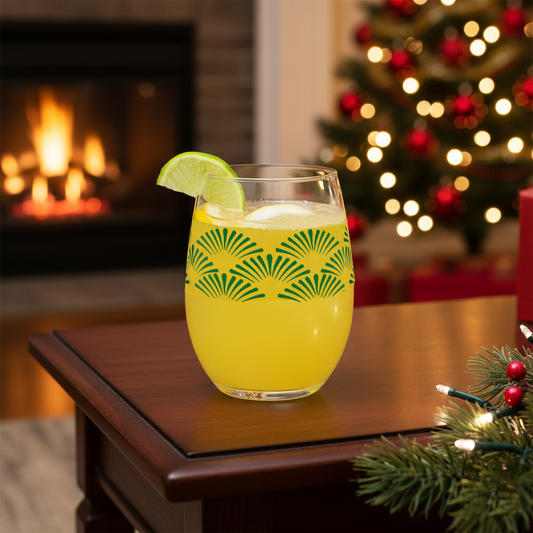 Green Deco stemless wine glass with an Art-Deco fan design and filled with a cocktail sitting on a wooden table in a festive setting with Christmas tree and fireplace.