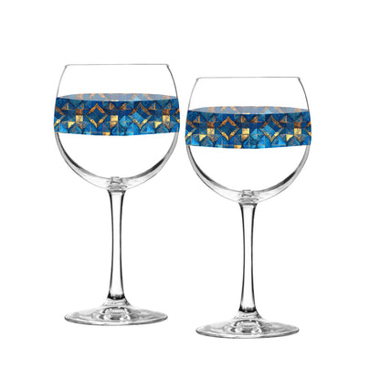 Two balloon wine glasses with turqoise and gold geometric design on a white background
