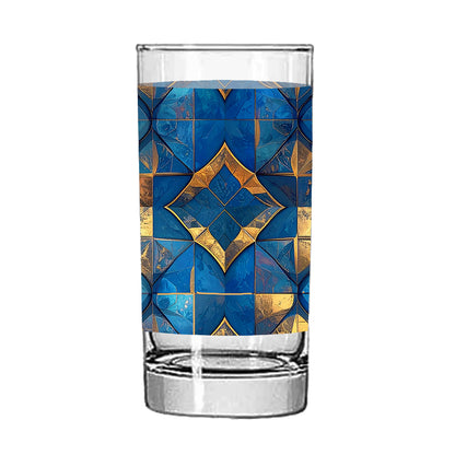 Clear highball glass with turqoise and gold geometric design on a white background
