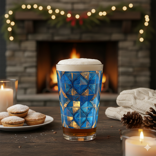 Moroccan Treasure pint glass with turquoise and gold design, filled with beer and foam head  on a festive table in front of a fireplace.