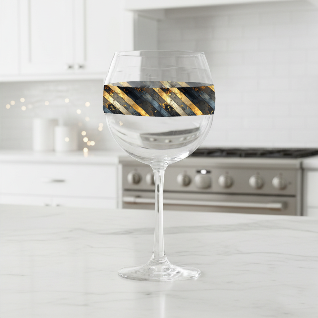 Obsidian Stripes balloon wine glass with gold and black diagonal stripes on a kitchen counter