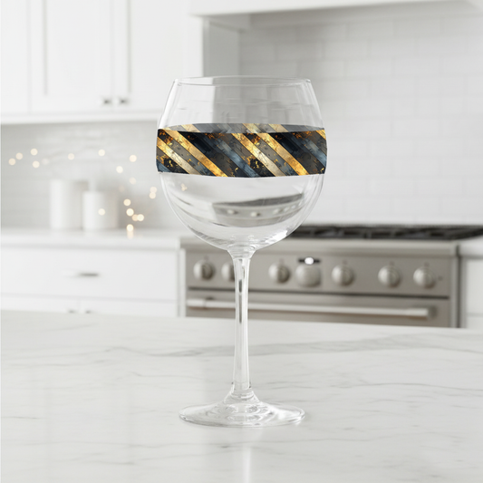 Obsidian Stripes balloon wine glass with gold and black diagonal stripes on a kitchen counter