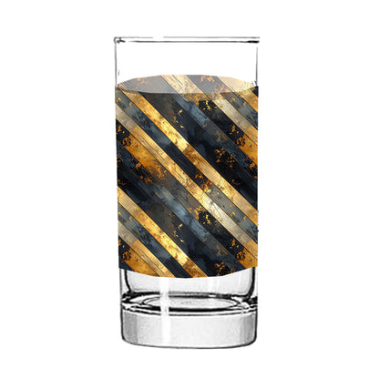 Clear highball glass with gold and black striped pattern on a white background