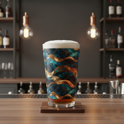 Opulent Teal pint lass filled with beer in at teal and gold wavy design on a bar counter with bottles and glasses in the background